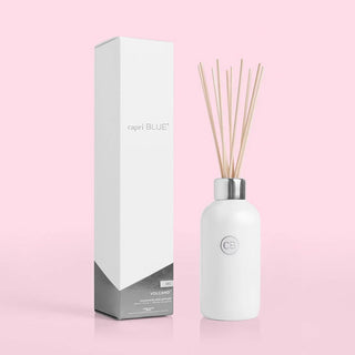 A white Capri Blue reed diffuser withvolcano fragrance, alongside its packaging box.