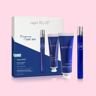 A fragrance gift set by Capri Blue, featuring a blue box with a Volcano perfume bottle and a mini hand cream tube, all in a coordinated blue color scheme.