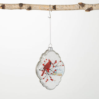 Decorative glass ornament with a cardinal and berries on a white background