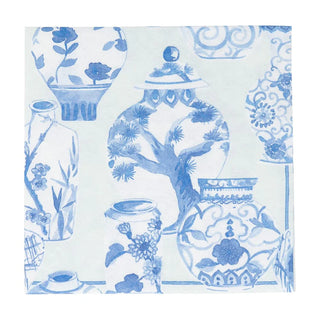 A patterned luncheon napkin with blue floral designs and porcelain motifs on a white background.