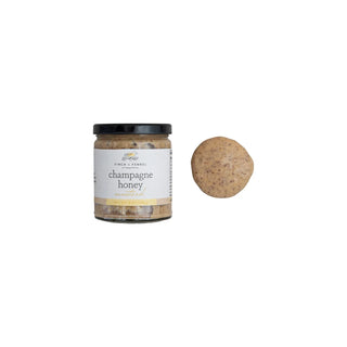A jar of Champagne Honey Mustard with a label showing the product name and a helping of horseradish next to it, finch and fennel 