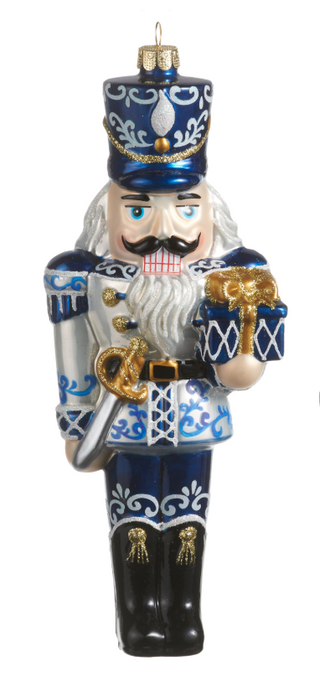 Chinoiserie Nutcracker Ornament Assorted
A traditional Christmas nutcracker ornament featuring a blue and white decorated soldier with a white beard, holding a gold gift box, on a plain white background.