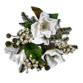 An artificial floral arrangement featuring white magnolia flowers, green magnolia leaves, pine branches, and clusters of small white berries on a plain white background. Christmas Magnolia Candle Ring 4"