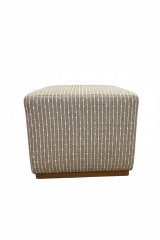Colby Ottoman in Beige & White Stripe
A square upholstered bench or ottoman in beige fabric with a white dotted vertical stripe pattern and a medium brown wood base