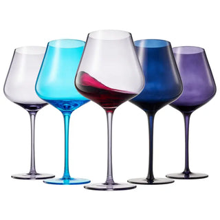 A set of five colored wine glasses in blue, clear, white, and purple, with a clear stem and base, filled with liquid.
