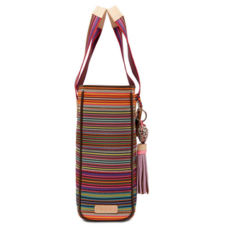 A multicolored woven tote bag with leather accents, a heart charm, and a tan handle.
