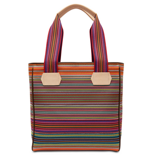 A multicolored woven tote bag with leather accents, a heart charm, and a tan handle.