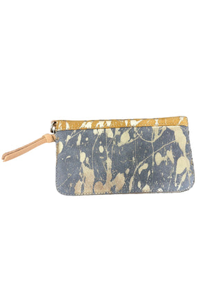 Consuela Beau Essential Wallet MUSTARD
A small zip-around pouch with a gray and beige paint-splatter pattern, a tan leather zipper pull, and a tan leather trim along the top, placed on a textured concrete surface.
