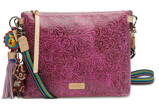 Pink textured handbag with colorful strap and decorative elements on a white background