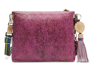Purple textured handbag with decorative strap and tassel on a white background