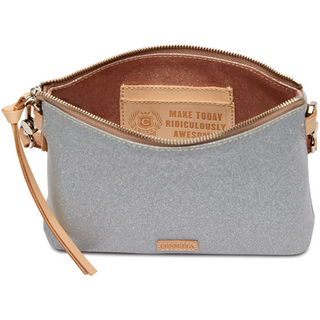 A floral embroidered Consuela Tink Midtown Crossbody handbag with multicolored flowers on a grey background, featuring a natural leather trim and a detachable woven strap.