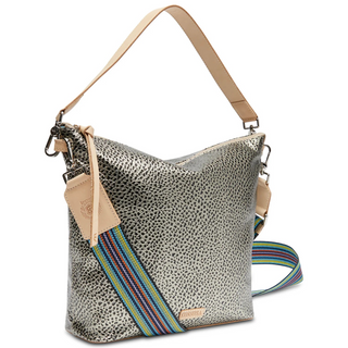 A Consuela Hobo bag with a gold and black metallic dotted pattern and a woven multicolored crossbody strap.