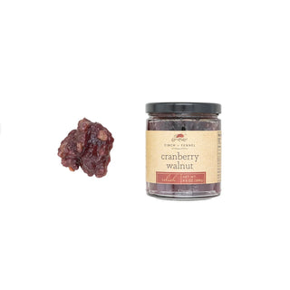 A jar of Cranberry Walnut Relish next to a small amount of the product displayed outside the jar, finch and fennel