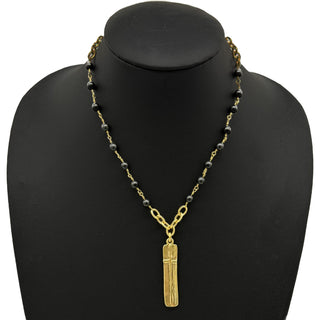 Necklace with black beads and gold cross on pendant 