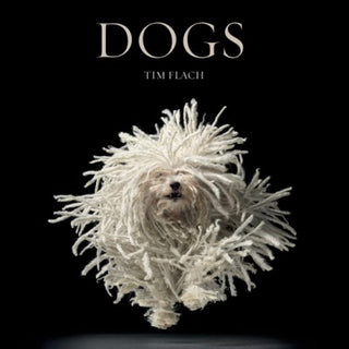 A book cover for 'Dogs' by Tim Flach, featuring a high-key photograph of a white, fluffy dog appears to be in motion, creating a dynamic and textured visual effect. Dogs Book