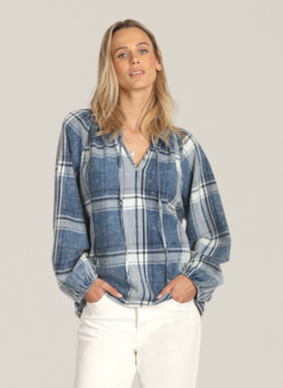 Woman wearing a blue plaid shirt against a plain background