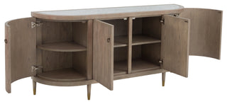 A wooden credenza with a white marble top, featuring four doors with brass hardware, set on short legs.