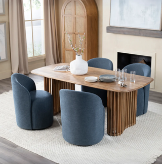 Dining room with wooden table and blue chairs in a well-lit room.