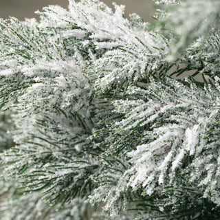An artificial pine tree with faux frost on its branches, standing on a grey base.