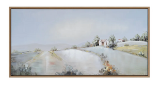 A framed canvas wall art featuring a landscape with wildflowers, cottages, and a blue sky.