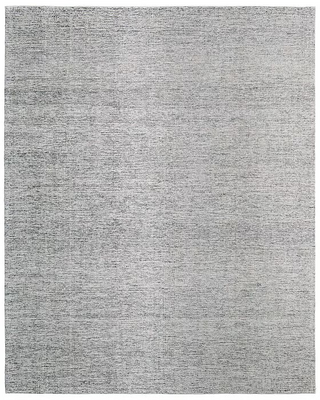 A light gray, solid patterned rug with a subtle texture, from the Freemont Collection by Thom Filicia.