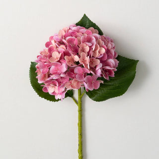 A single artificial fuschia hydrangea stem with green leaves and pink flowers.