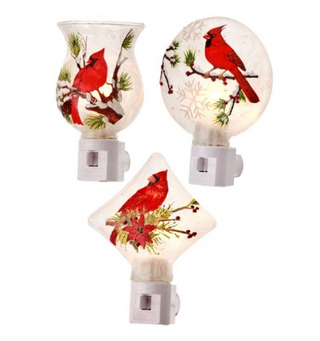 Glass Cardinal Night Light Assorted
decorative night light with white plastic plugs and glowing frosted glass shades, each printed with a red cardinal perched on a branch with pine needles and berries. One shade is rounded and vase-shaped, one is oval with a snowflake motif, and one is diamond-shaped. berry red green poinsettia 