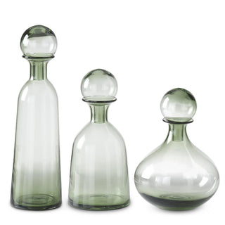 Three green glass decanters of varying sizes on a white background. Green Glass Vase with Stopper Assorted