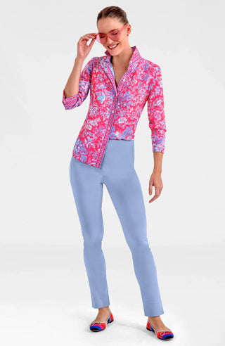 A woman smiling and wearing a pink and purple floral boyfriend shirt with long sleeves, shell buttons, and a collar.