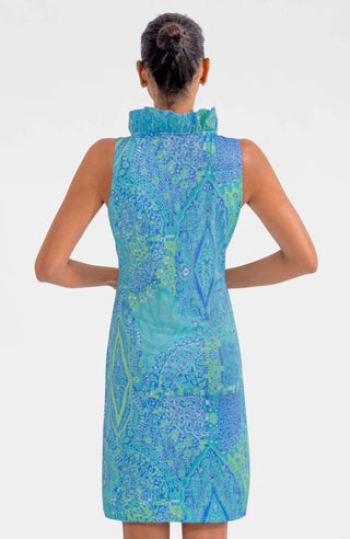 A woman wearing a sleeveless, ruffle neck, turquoise print dress with a stand-up collar.