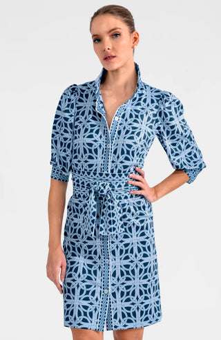 A model wearing a navy and white geometric patterned dress with a mandarin collar, puff sleeves, and a belt.