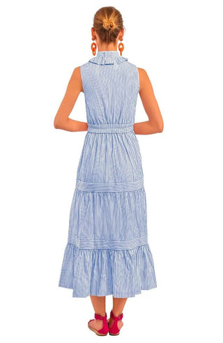 A model wearing a blue Gretchen Scott wash and wear hope midi/maxi dress with a double pleated collar, tiered banded gathered skirt, elasticized waist, side seam pockets, and coordinating inside back panel.