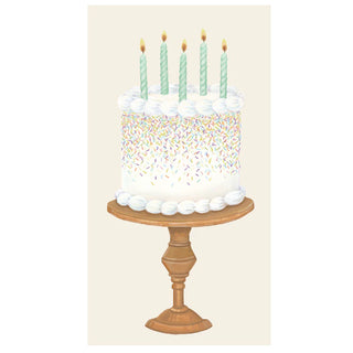 A birthday cake with candles and multicolored sprinkles on top, placed on a wooden stand printed on a guest towel. Hester & Cook Birthday Cake Guest Napkins
