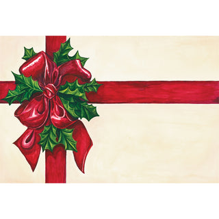 Decorative Christmas paper placemat with red ribbon and holly leaves on a beige background. Hester & Cook Christmas Present Placemats
