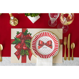 Christmas-themed table setting with red and gold decorations on a white background