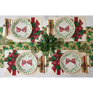 Christmas-themed table setting with plates, placemats, and cutlery on a white background