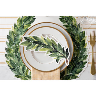 Placemat with green leaf design on a white table setting with gold accents