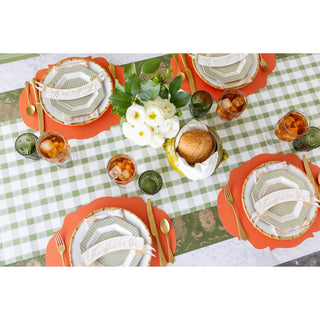 Thanksgiving table setting with place mats, plates, and a centerpiece on a checkered paper table runner