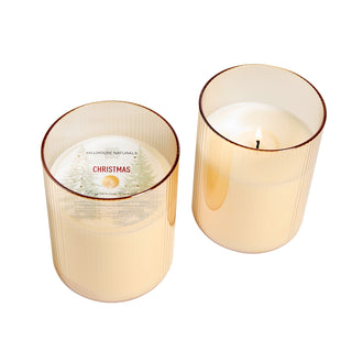 Two lit candles in ribbed glass containers on a white background, Hillhouse Naturals Christmas in Gold Glass 15 oz Candle