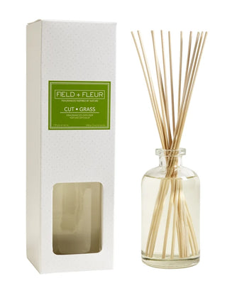 Diffuser with reeds and packaging labeled 'Field + Fleur' on a white background