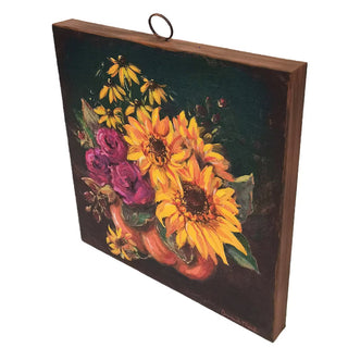 Jeweled Flower Pumpkin Large Art
painting on metal depicting a vibrant floral arrangement with yellow sunflowers, purple roses, and black-eyed flowers in a pumpkin-shaped vase against a black and green background. The painting is shown hanging from a metal ring at the top.