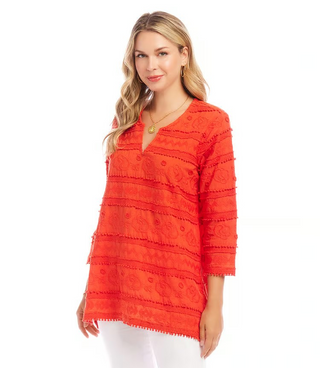 A woman wearing an orange tunic with 3/4 length sleeves and embroidery details.