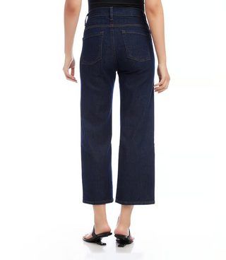 A person standing wearing Karen Kane Cropped Wide Leg Jeans in a dark wash, paired with a black top and black sandals.