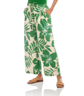 Person wearing green and white floral pants on a white background