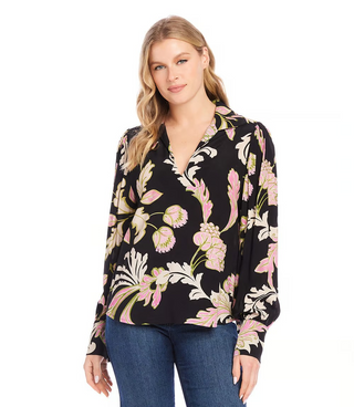 A woman wearing a black floral print blouson V-neck top and blue jeans.
