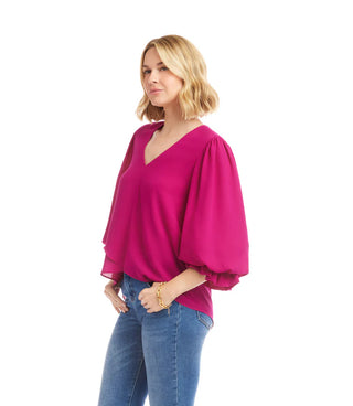 Woman wearing a bright pink blouse with balloon sleeves on a white background. Karen Kane Layered Sleeve Asymmetric Top, Magenta