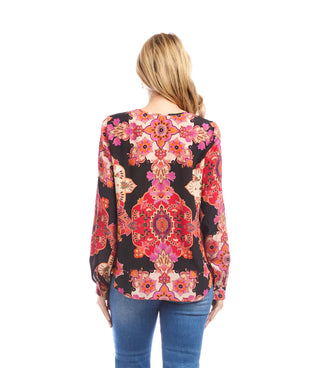 Woman wearing a colorful floral patterned top on a white background. Karen Kane Long Sleeve Shirred Blouse, Red/Magenta Print