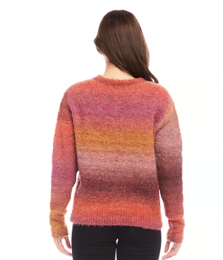 A woman wearing a multicolored ombre boucle sweater with a crew neck.