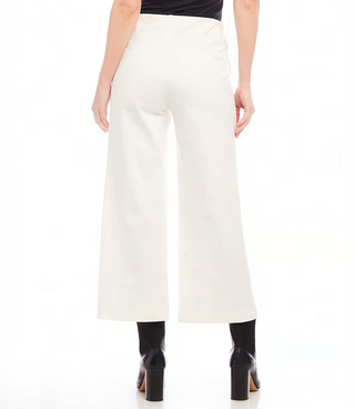 A pair of off white pintuck wide leg pants with an elastic waistband, displayed on a model with black boots.