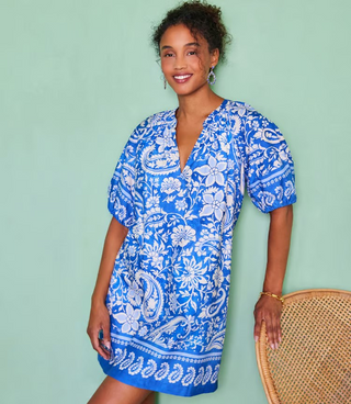 A model wearing a Karen Kane puff sleeve peasant dress with a floral paisley pattern in blue and white colors.